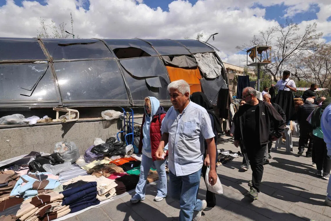 People walk past a metro station that was destroyed during a missile strike at the Grand Bazaar in Tehran.