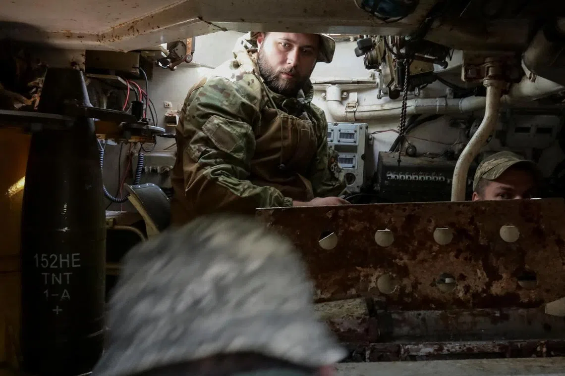 A Ukrainian soldier loads a shell in a self-propelled howitzer along the Donetsk region in Ukraine.
