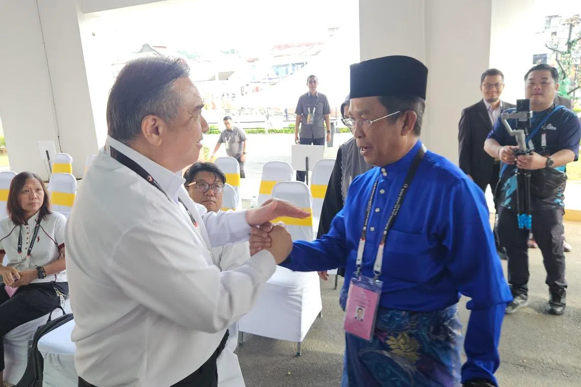 PH national deputy chairman and DAP secretary-general Anthony Loke (left) and Negeri Sembilan BN chairman Jalaluddin Alias greeting each other at the nomination centre on July 18.