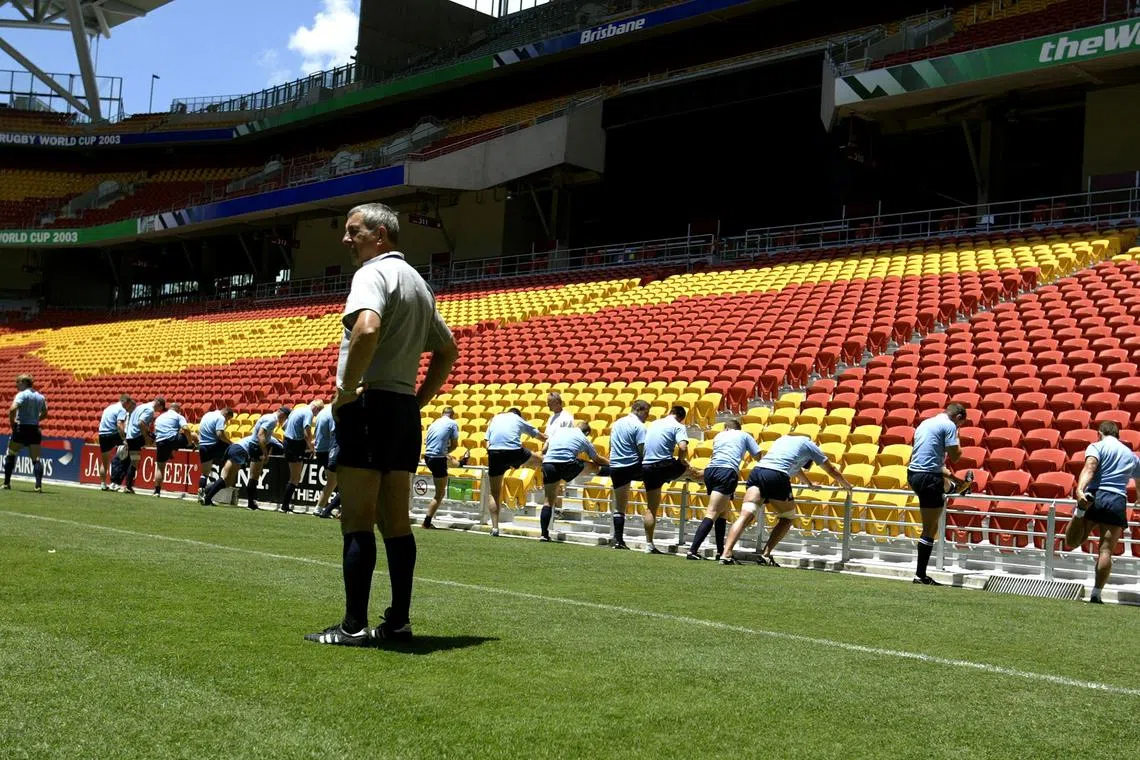 FILE PHOTO: Scotland coach Ian McGeechan (C) looks on as his team stretches during a training session at Lang Park in Brisbane November 6, 2003. Scotland will play Australia in their World Cup quarter final match in Brisbane on Sunday. REUTERS/Kieran Doherty  KD/PB/File Photo
