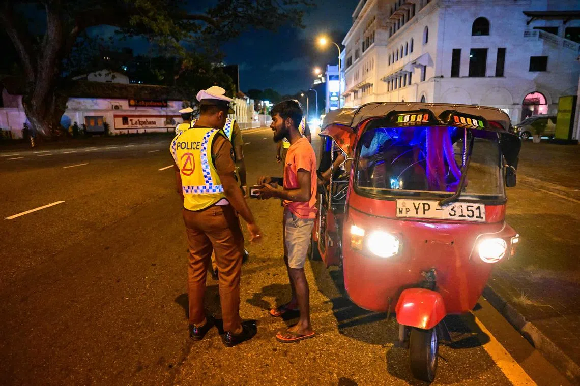 Police officers inspecting an auto-rickshaw at a checkpoint in Colombo on Sept 21. Sri Lanka imposed a night-time curfew across the country, despite a peaceful presidential election.