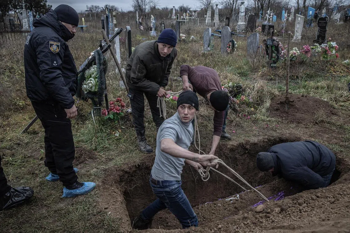 Local residents help police and war crimes investigators exhume the body of a 15-year-old girl, who local residents said had been executed by Russian forces along with several men whose bodies had been exhumed the day before, in the recently liberated village of Pravdyne, Ukraine, Nov. 29, 2022. On Tuesday, American officials pledged to give Ukraine $53 million to repair the electrical grid, and sought to rally other allies to make similar offers. (Finbarr OÕReilly/The New York Times)