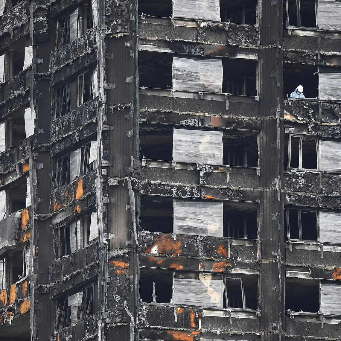 An official works in the burnt out remains of the Grenfell Tower residential building in London, Britain, on Sept 20, 2017.