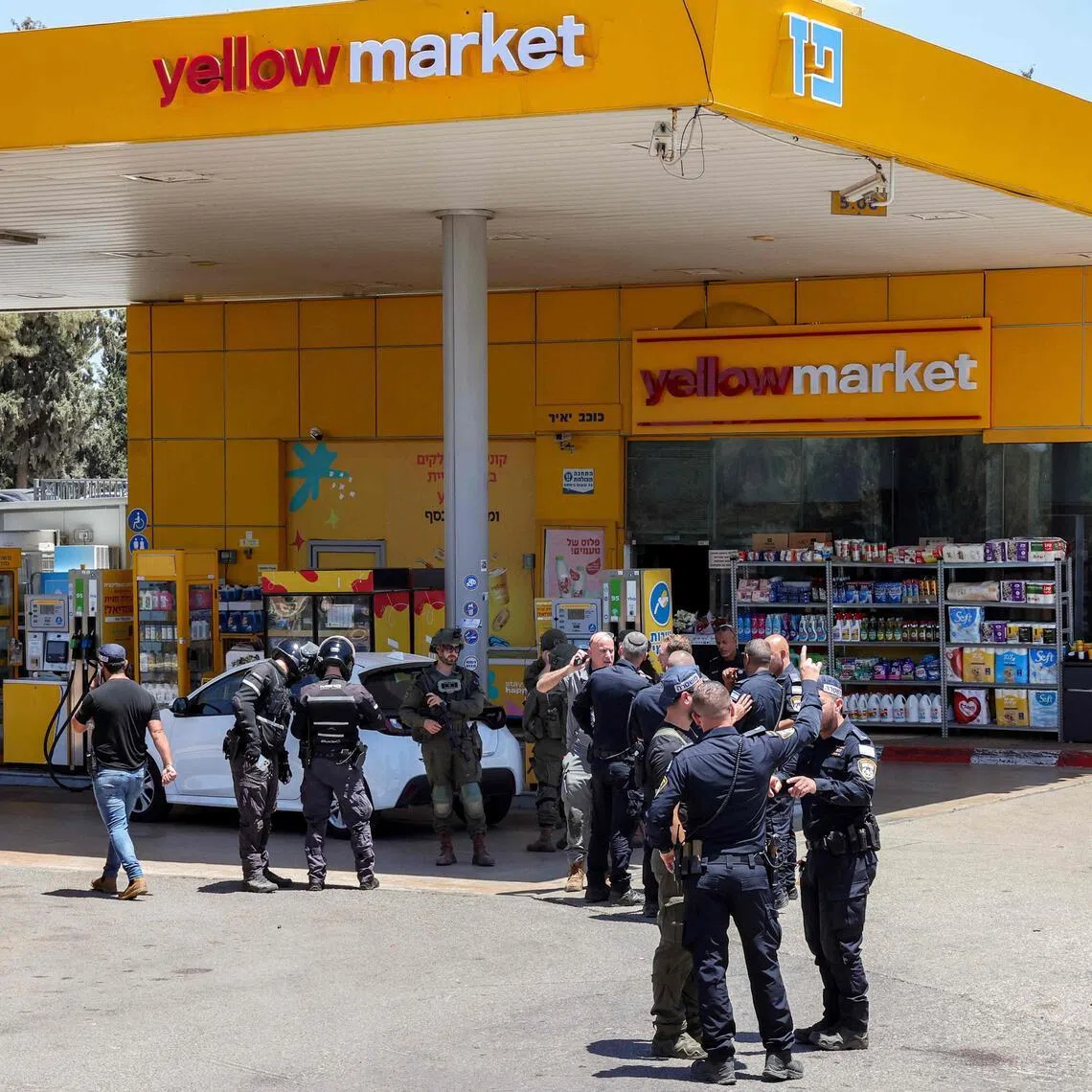 Israeli security forces gather at a petrol station following a suspected shooting attack near the town of Kokhav Yair close to the occupied West Bank on June 7, 2026.  