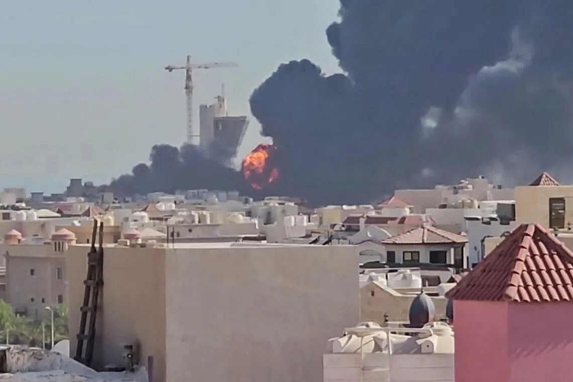 A plume of black smoke and flames billowing over the town of Mangaf, south of Kuwait City.