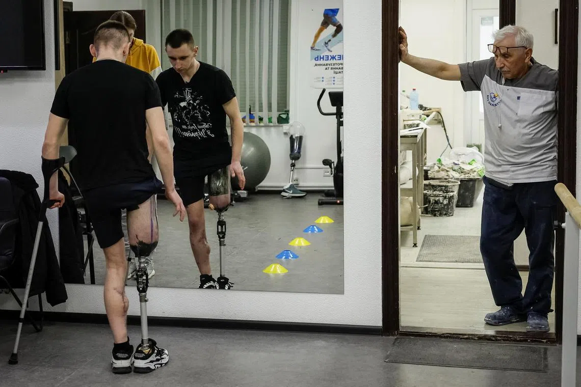 Dmytro Zilko, a soldier and a patient of the clinic exercises on a new prosthesis with rehabilitation specialist Maria in a prosthetics clinic in Kyiv, Ukraine.