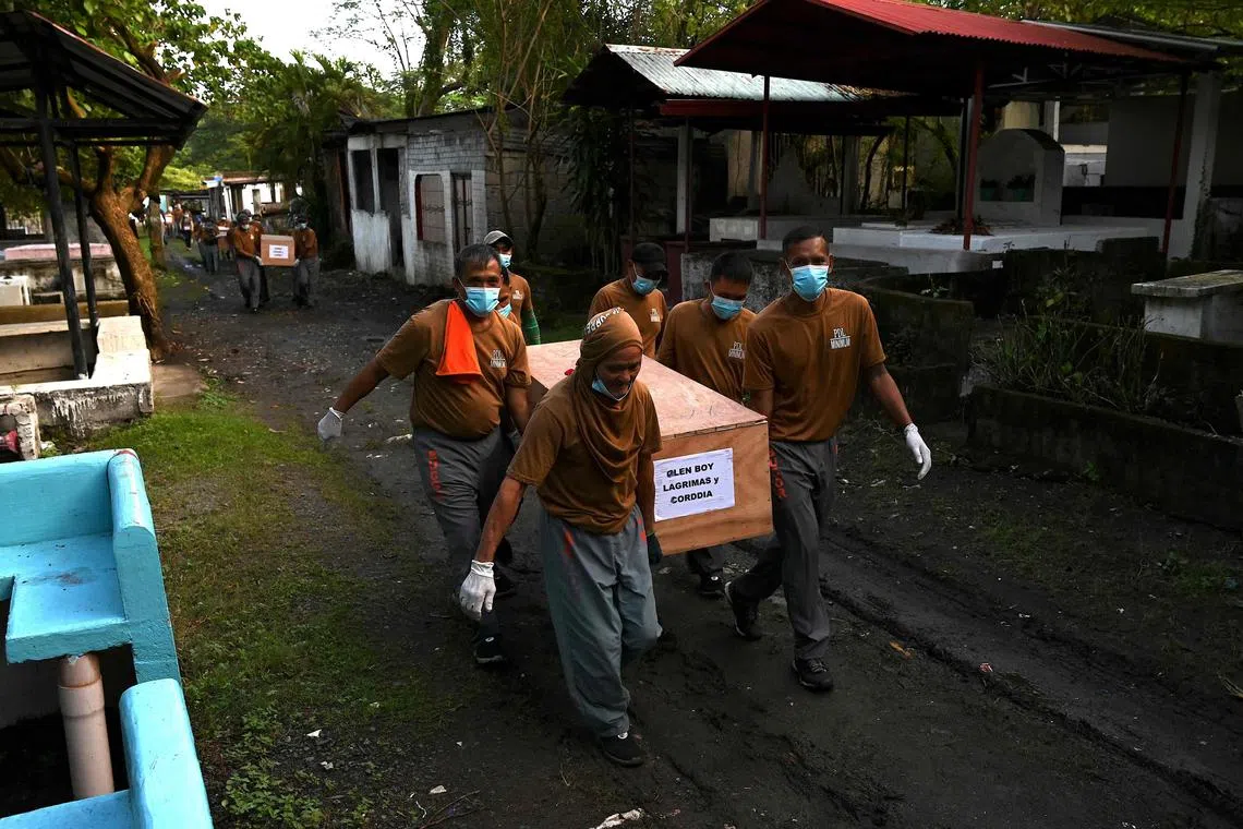 Prison inmates carry a coffin during a mass burial of 70 unclaimed bodies of prisoners at New Bilibid Prison Cemetery in Muntinlupa, metro Manila on Dec 2, 2022. 