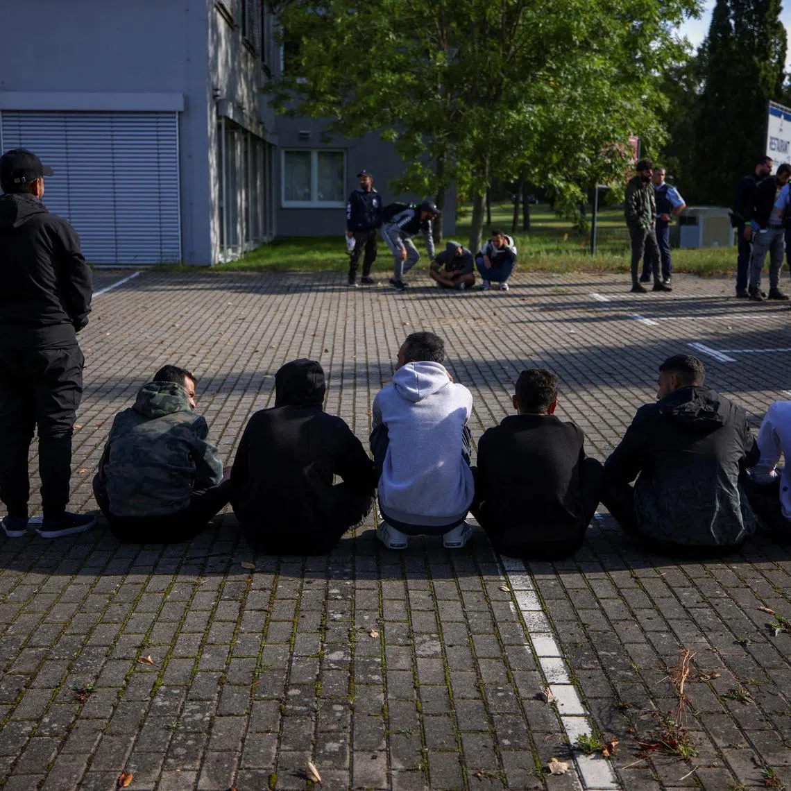 FILE PHOTO: Suspected illegal migrants sit on the ground after they were detained by German police during their patrol along the German-Polish border to prevent illegal migration, in Forst, Germany, September 20, 2023. REUTERS/Lisi Niesner/File Photo