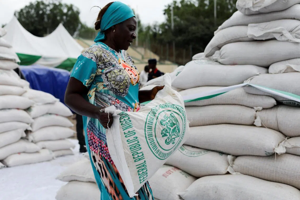 FILE PHOTO: A woman receives a bag of food from the government during the distribution of food items by the government to cushion the high cost of living in Abuja, Nigeria, September 20, 2022. REUTERS/Afolabi Sotunde/File Photo