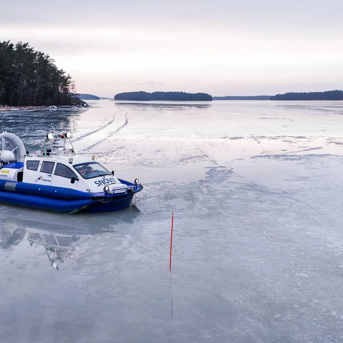 An hovercraft used also to bring home kids from school, floats on the ice of the Finnish archipelago on March 3, 2026 in Pargas, Finland. Due to unusually thick ice this winter, a hovercraft called "Snovit" ("Snow White") has replaced the ferries that normally transport 12-year-old Hugo Wickstrom, nine-year-old Julia Jalkanen and eight-year-old Nils-Johan Ostman to the islands where they live in southwestern Finland's Pargas archipelago. (Photo by Alessandro RAMPAZZO / AFP)