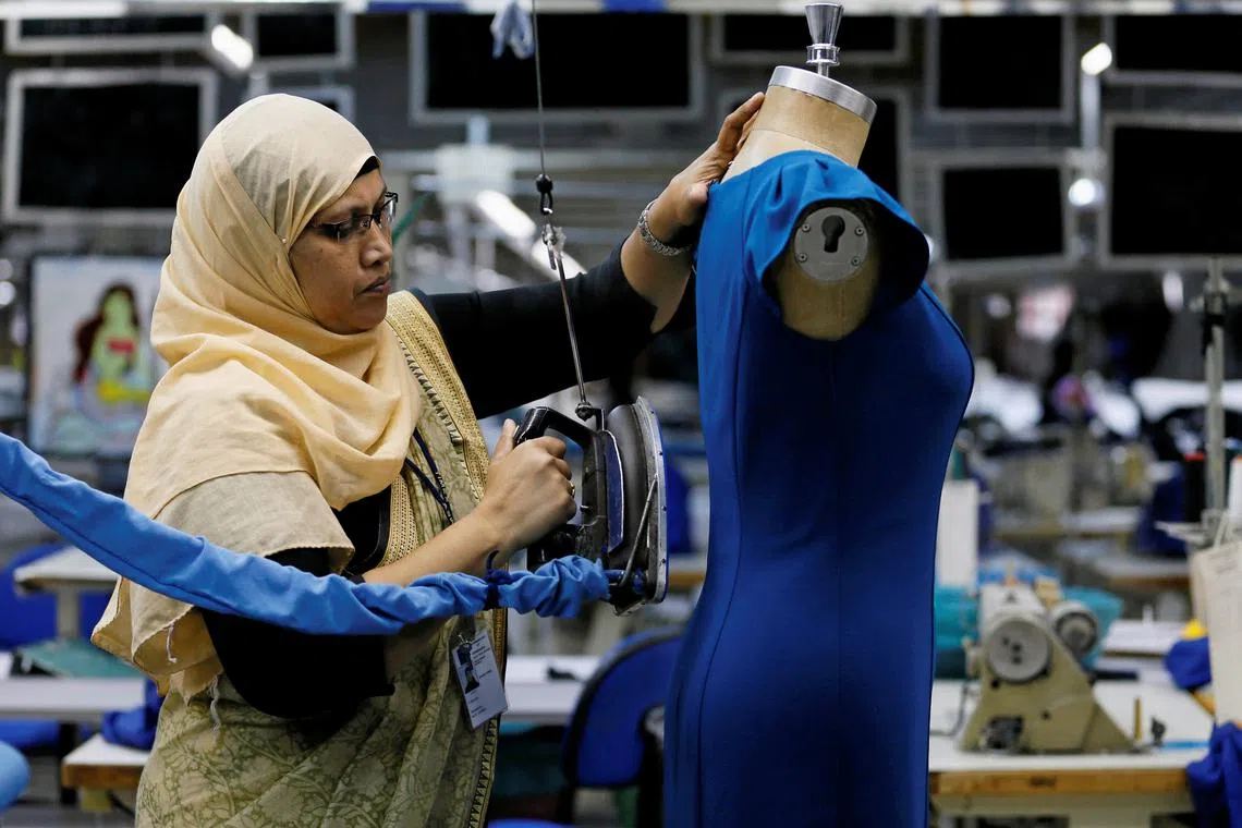 A woman irons a dress at Timex garments factory in Wattala, Sri Lanka June 13, 2018. Picture taken June 13, 2018. REUTERS/ Dinuka Liyanawatte/ File photo