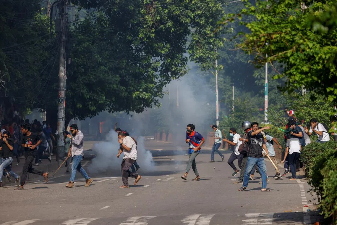 People run as police fire teargas during a coffin rally of anti-quota protesters at the University of Dhaka, a day after the clash with Bangladesh Chhatra League, the student wing of the ruling party Bangladesh Awami League, and anti-quota protesters, in Dhaka, Bangladesh, July 17, 2024. REUTERS/Mohammad Ponir Hossain