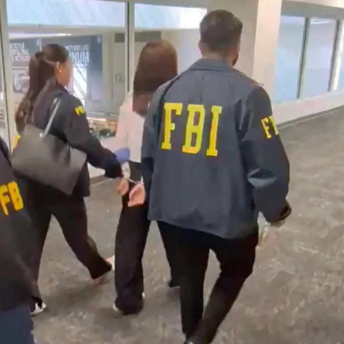 A California woman, Wanying Zhang, also known as Heather, being taken by the FBI in Los Angeles on Oct 4.