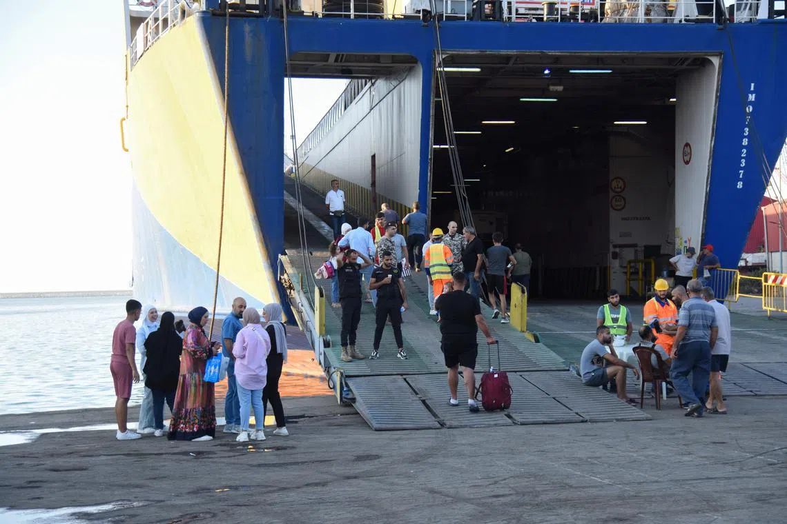 FILE PHOTO: People wait at the port to board a ferry heading to Turkey, amid the ongoing hostilities between Hezbollah and Israeli forces, in Tripoli, northern Lebanon October 5, 2024. REUTERS/Omar Ibrahim/File Photo