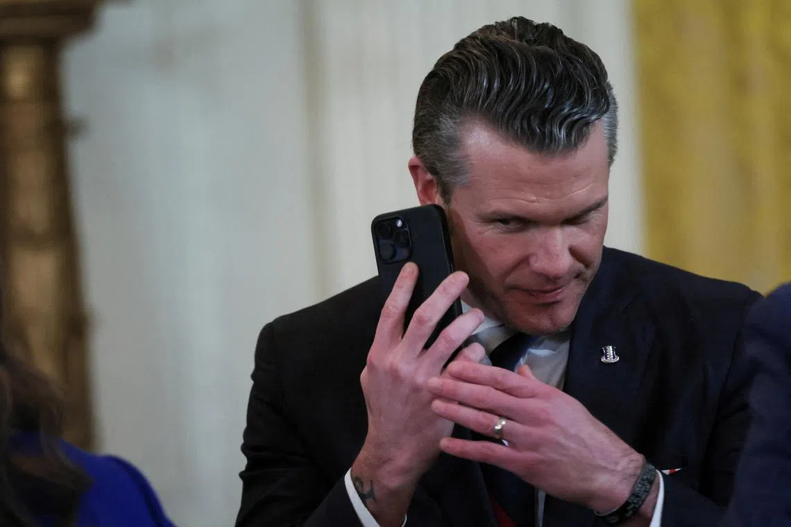 US Defense Secretary Pete Hegseth uses a phone in the East Room at the White House on Feb 4.