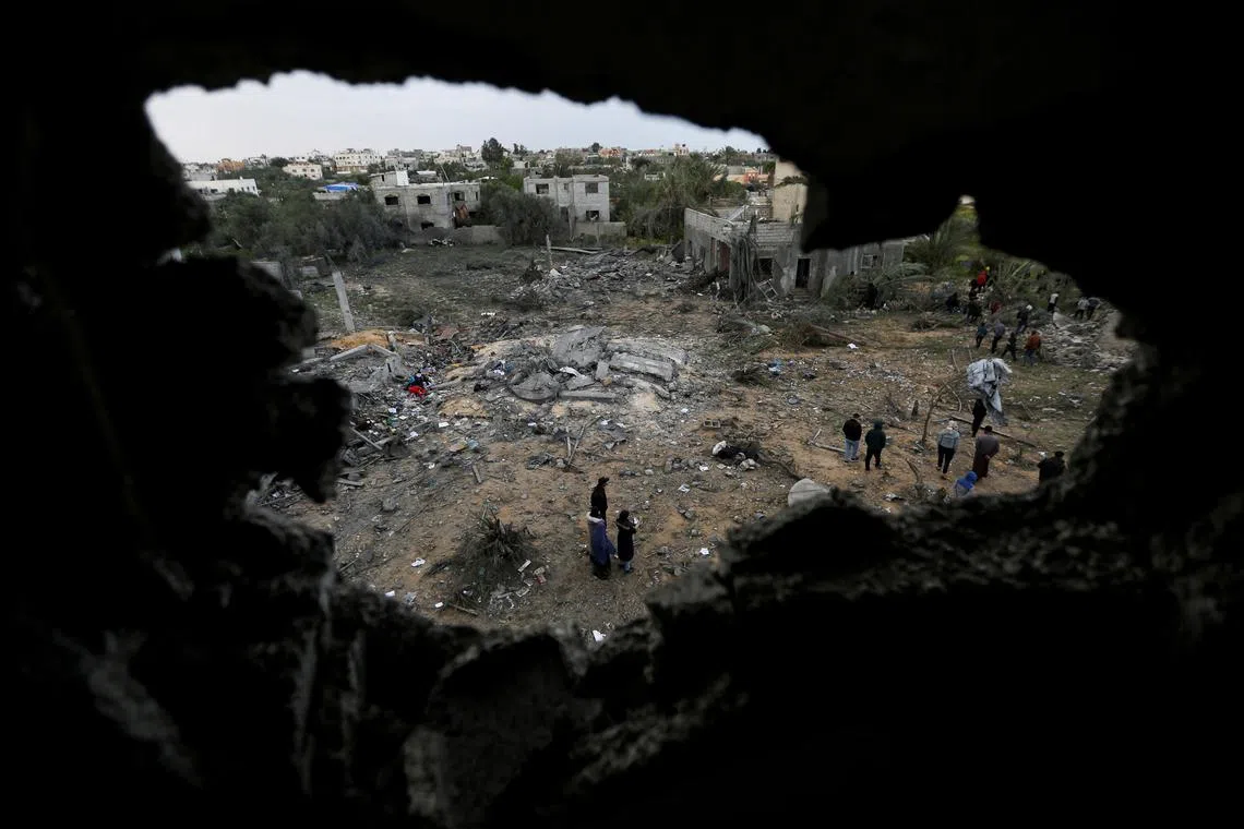 Palestinians inspect the site of an Israeli strike on a house, in Khan Younis in the southern Gaza Strip March 20, 2025. REUTERS/Hatem Khaled