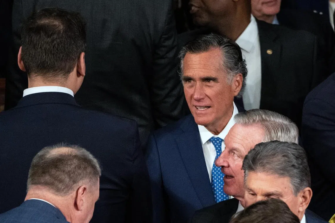 Senator Mitt Romney (right) exchanges words with Representative George Santos before the State of the Union address in Washington.