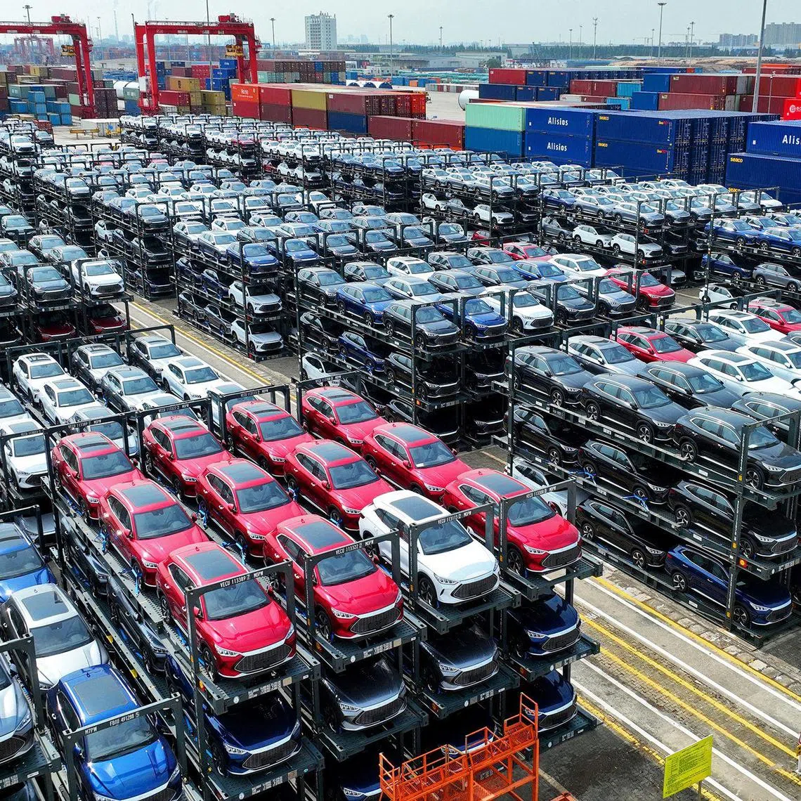 (FILES) The file photo taken on September 11, 2023 shows BYD electric cars waiting to be loaded on a ship stacked at the international container terminal of Taicang Port at Suzhou Port, in China’s eastern Jiangsu Province. China's BYD has overtaken US electric vehicle giant Tesla as the world's leading EV deliverer, according to recent sales figures. (Photo by AFP) / China OUT