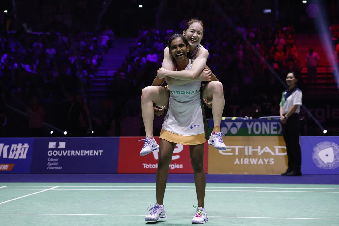 Malaysia's Pearly Tan (top) and Thinaah Muralitharan celebrating after winning their Badminton World Federation World Championships women's doubles semi-final match.