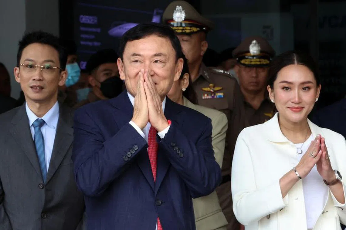 Former Thai Prime Minister Thaksin Shinawatra, who is expected to be arrested upon his return as he ends almost two decades of self-imposed exile, gestures while flanked by his son Panthongtae Shinawatra and daughter Paetongtarn Shinawatra at Don Mueang airport in Bangkok, Thailand August 22, 2023. REUTERS/Athit Perawongmetha/File Photo