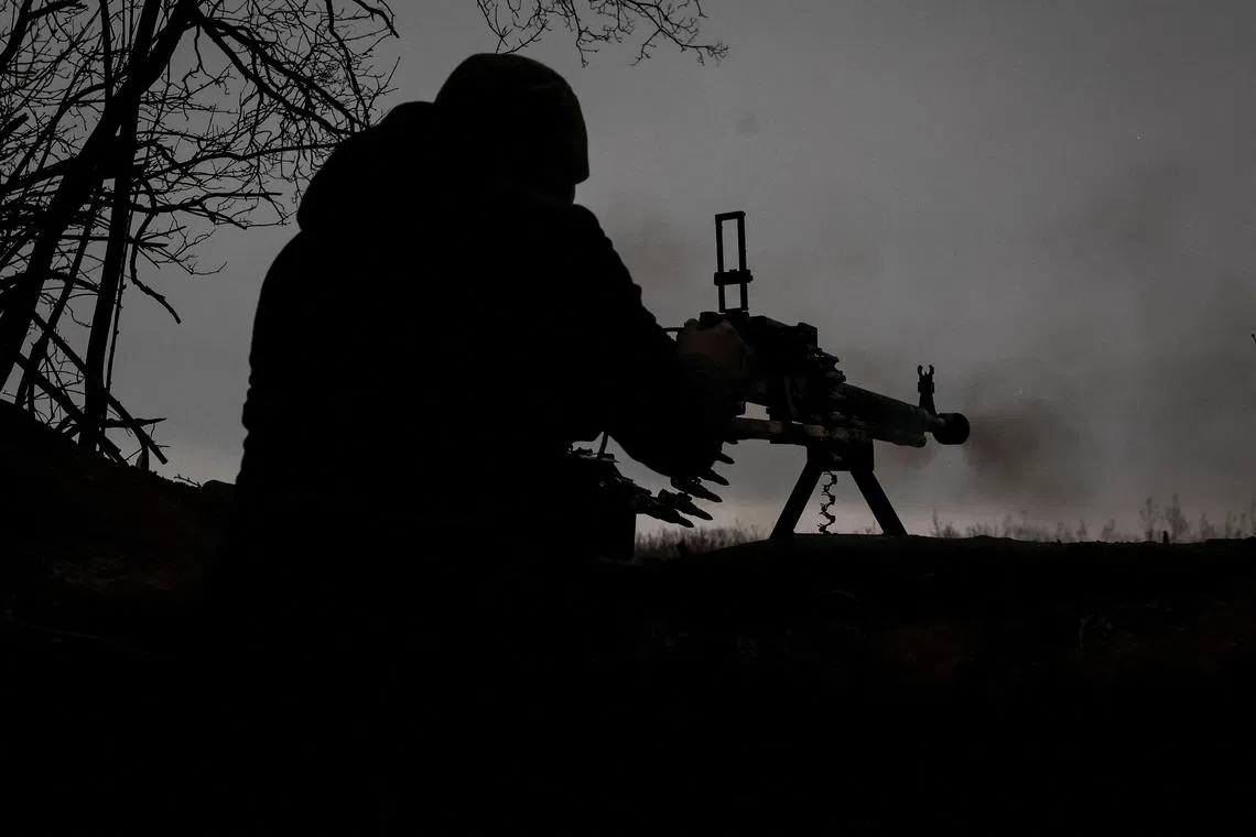 A Ukrainian serviceman fires a machine gun at a position on the front line, near Soledar, on Jan 14, 2023.