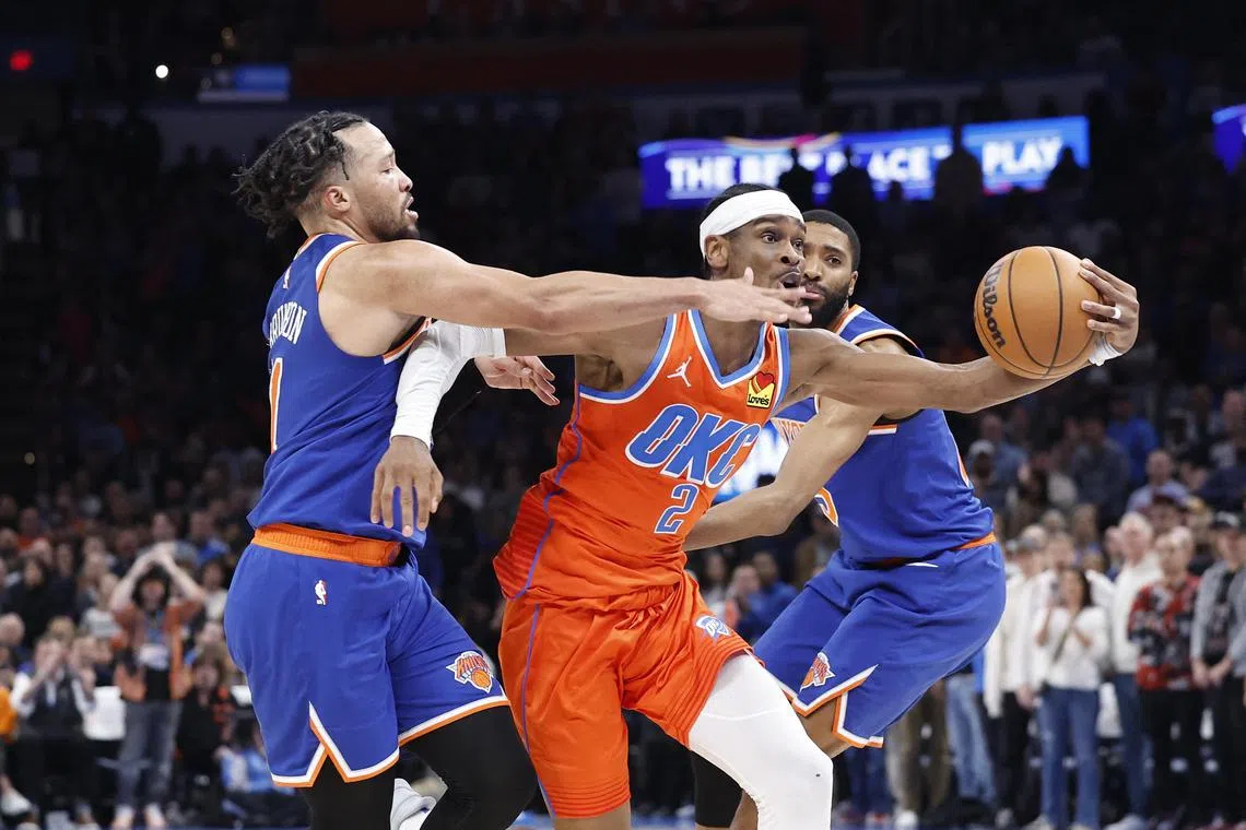 Oklahoma City Thunder guard Shai Gilgeous-Alexander drives between New York Knicks guard Jalen Brunson and forward Mikal Bridges during the second half at Paycom Centre.
