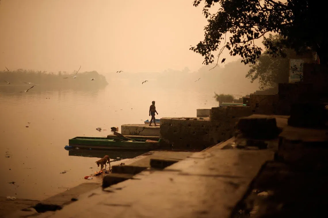 A man walks amidst heavy smog after praying on the bank of the river Yamuna, in the old quarters of Delhi, India.