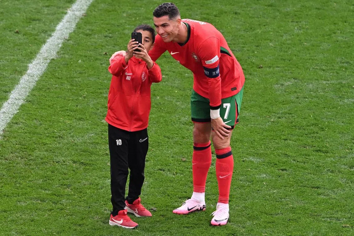 Soccer Football - Euro 2024 - Group F - Turkey v Portugal - Dortmund BVB Stadion, Dortmund, Germany - June 22, 2024
Young pitch invader takes a selfie with Portugal's Cristiano Ronaldo REUTERS/Carmen Jaspersen     TPX IMAGES OF THE DAY     