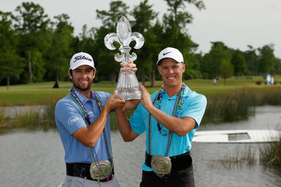 Davis Riley and Nick Hardy of the United States pose with the trophy and commemorative belts after their win at the Zurich Classic of New Orleans at TPC Louisiana.