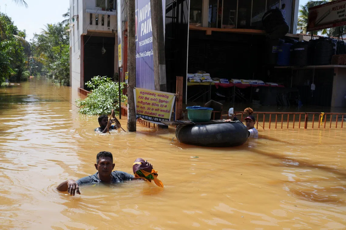 People wade through a flooded street, following Cyclone Ditwah in Kelaniya, Sri Lanka, November 30, 2025. REUTERS/Thilina Kaluthotage
