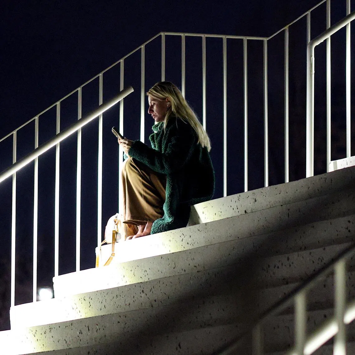 FILE PHOTO: A woman uses her smartphone as the Albanian government lifts a ban on TikTok after nearly a year, in Tirana, Albania, February  24, 2026. REUTERS/Florion Goga/File Photo