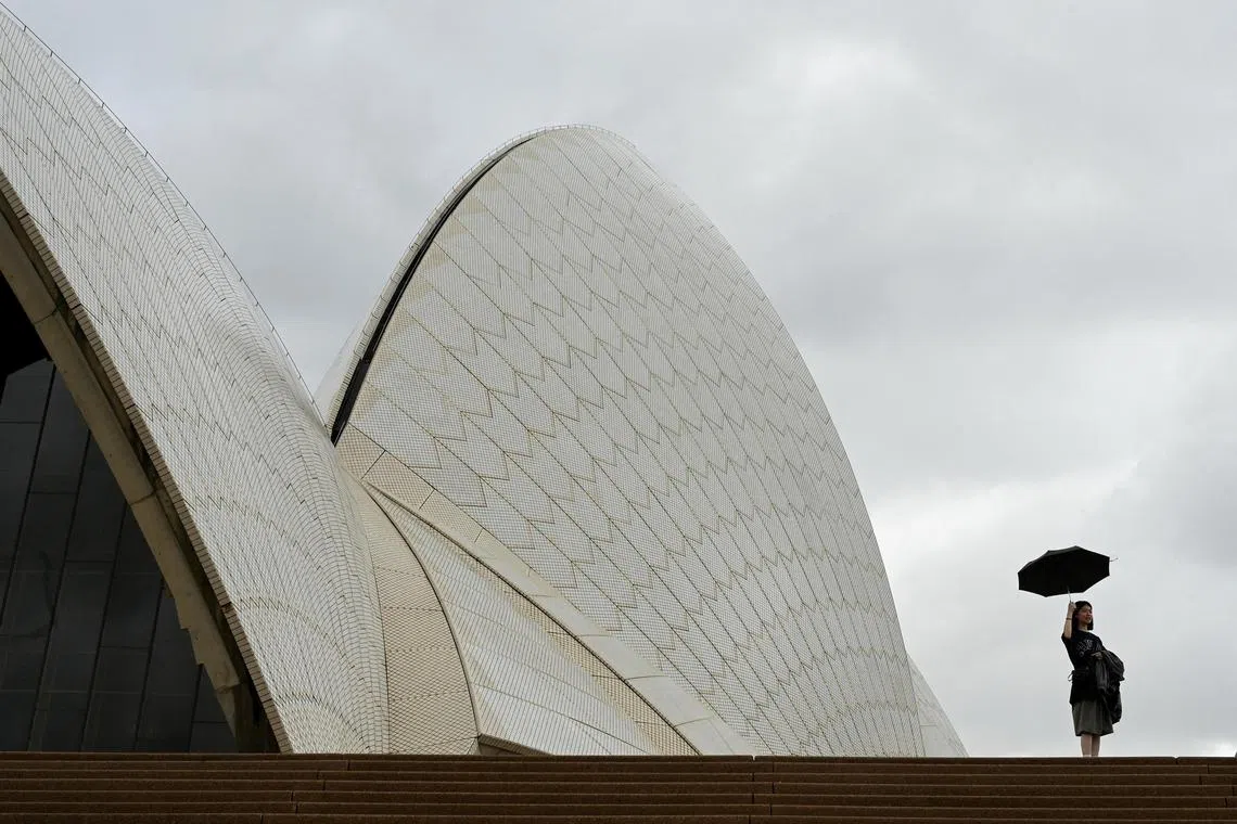 A woman holds up an umbrella at the Sydney Opera House during cloudy and rainy weather conditions in Sydney, Australia, April 20, 2023. Australia is like to to see a warmer, drier winter this year as the likely hot of an El Nino weather pattern grows. REUTERS 