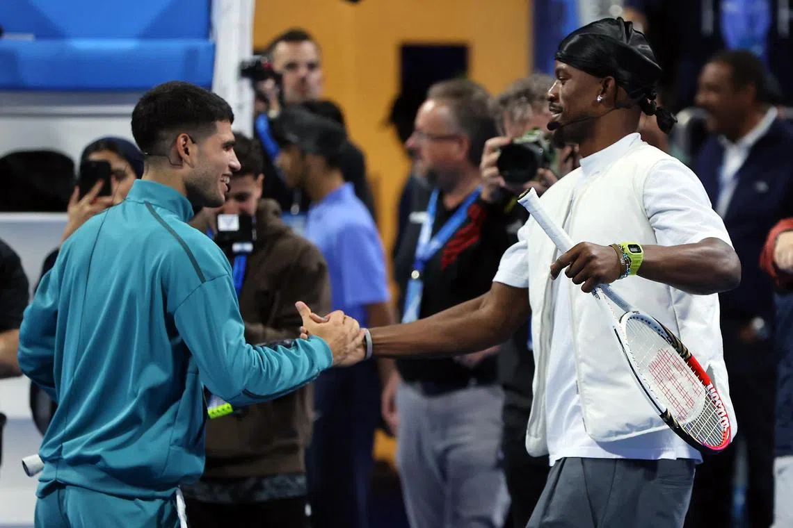 Golden State Warriors player Jimmy Butler shakes hands with Spain's Carlos Alcaraz at the Qatar Open.