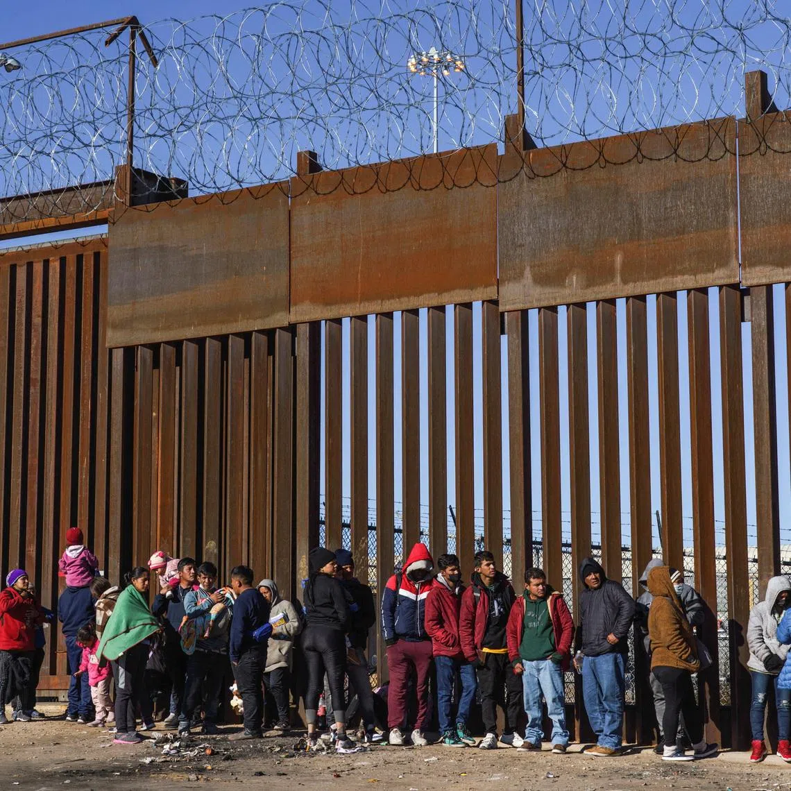 Migrants from Nicaragua, Ecuador and other nationalities are pictured at a door on the border wall waiting to be picked up by the United States Border Patrol in El Paso, Texas, U.S., January 4, 2023. REUTERS/Paul Ratje