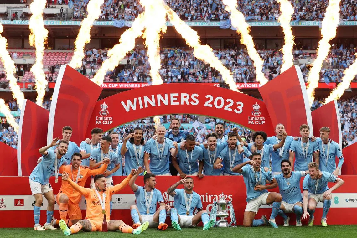 Manchester City players celebrate winning the FA Cup at Wembley stadium.