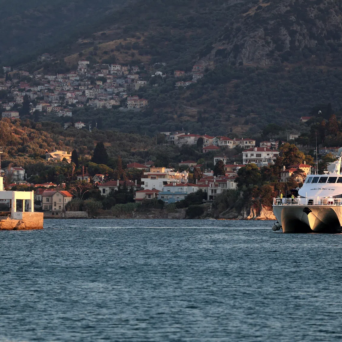 A boat with migrants transferred from Crete arrive at the port of Mytilene before being transferred to the temporary Kara Tepe refugee camp, as part of efforts to ease pressure on Crete following an increase in migrant arrivals by sea, on the island of Lesbos, Greece, August 23, 2026. REUTERS/Elias Marcou