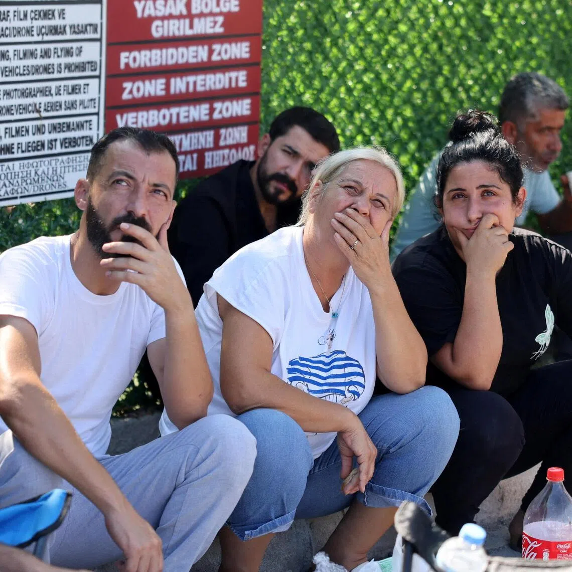 Relatives watch a rescue helicopter flying outside Kyrenia port, in Turkish-controlled northern Cyprus, on Aug 31. Twenty people are still missing after a crowded ferry carrying 267 people capsized on Aug 30.