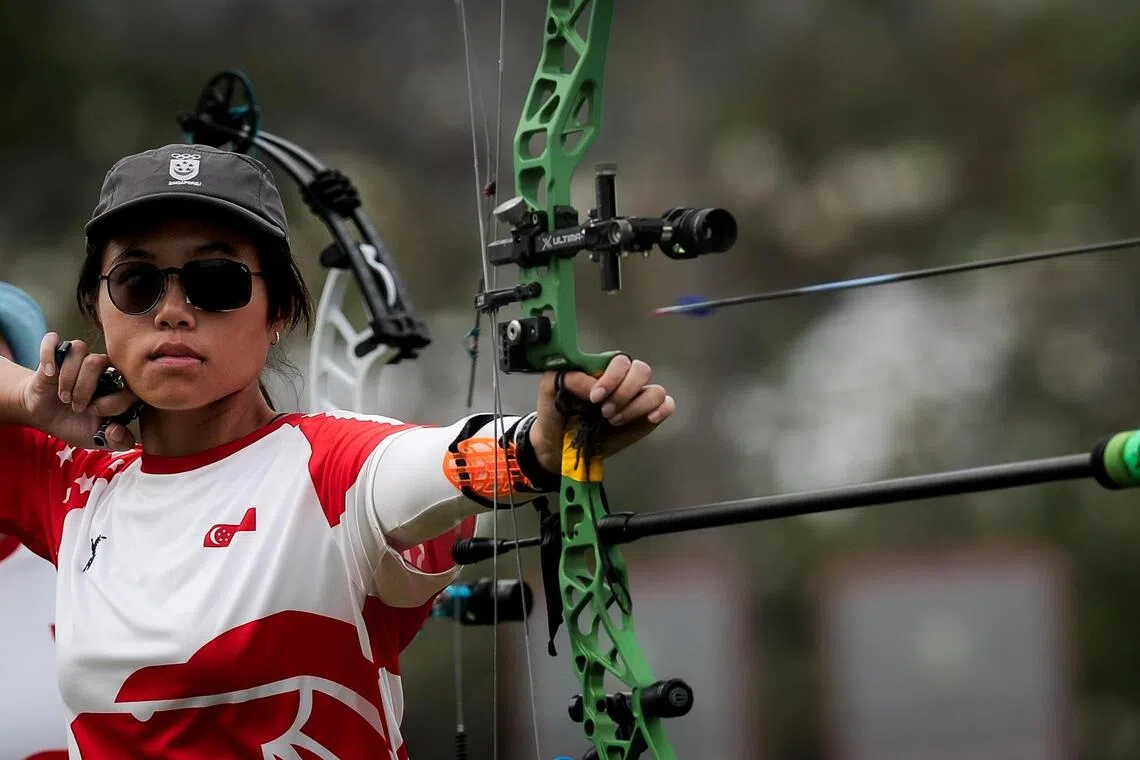 Singapore archer Jeannice Low competing in the women’s compound  team final against Indonesia at the Sports Authority of Thailand field in Bangkok. Her teammates are Madeleine Ong and Ellie Low.