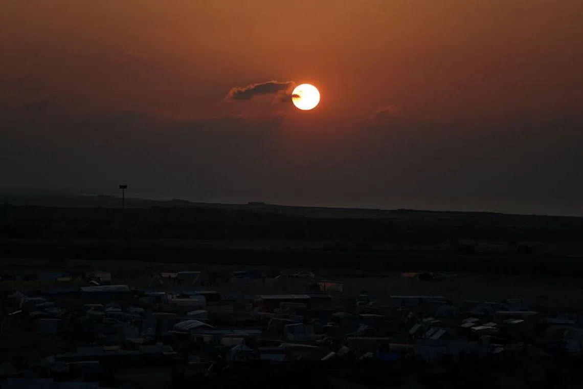 A general view shows a tent camp where displaced Palestinians, who fled their homes due to Israeli strikes, shelter amid the ongoing conflict between Israel and the Palestinian Islamist group Hamas, during sunset on the eve of the new year of 2024, in Rafah, southern Gaza Strip, December 31, 2023. REUTERS/Ibraheem Abu Mustafa