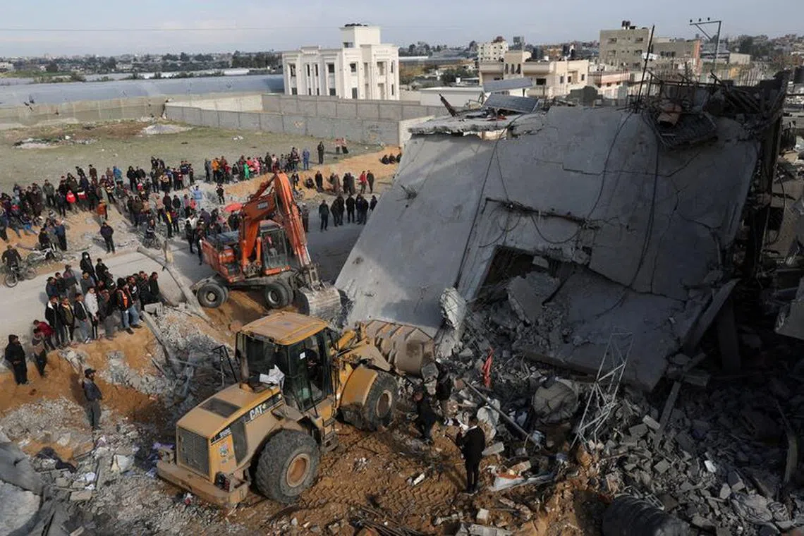 FILE PHOTO: Palestinians inspect a house hit by an Israeli strike, in Rafah in the southern Gaza Strip February 16, 2024. REUTERS/Ibraheem Abu Mustafa