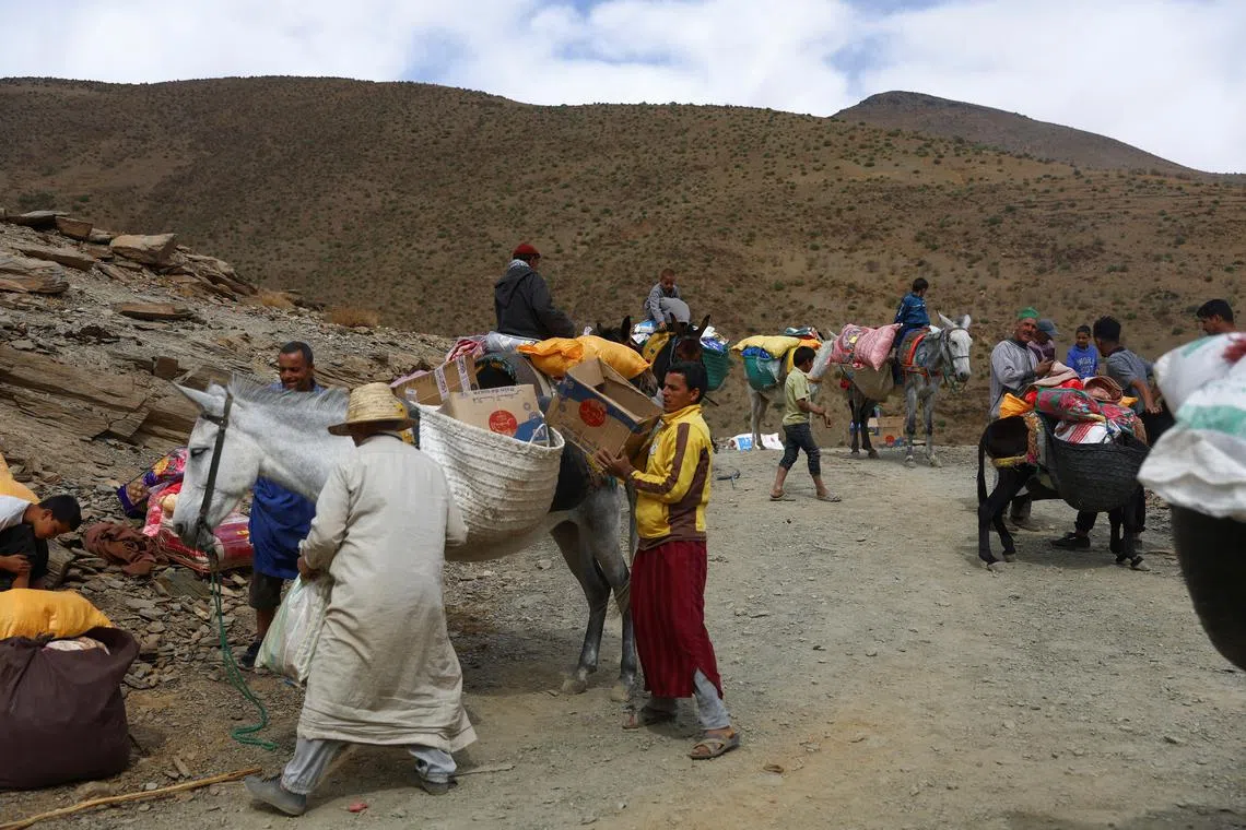 People load aid on animals to be distributed  in the aftermath of a deadly earthquake, in the rural village of Azermoun, on Sept 14.