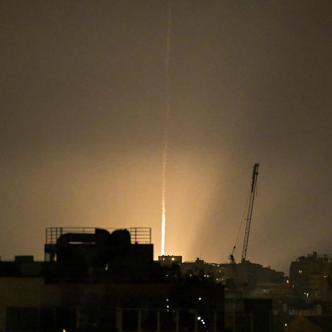 The sky is illuminated as an Iranian missile lands in Israel, amid the U.S.-Israeli conflict with Iran, as seen from Tel Aviv, Israel, March 12, 2026. REUTERS/Dylan Martinez