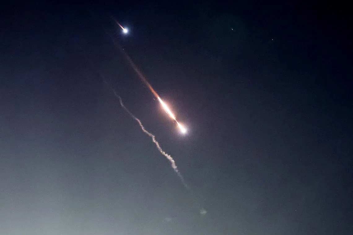 Objects are seen in the sky above Jerusalem after Iran launched drones and missiles towards Israel, in Jerusalem April 14, 2024. REUTERS/Ronen Zvulun
