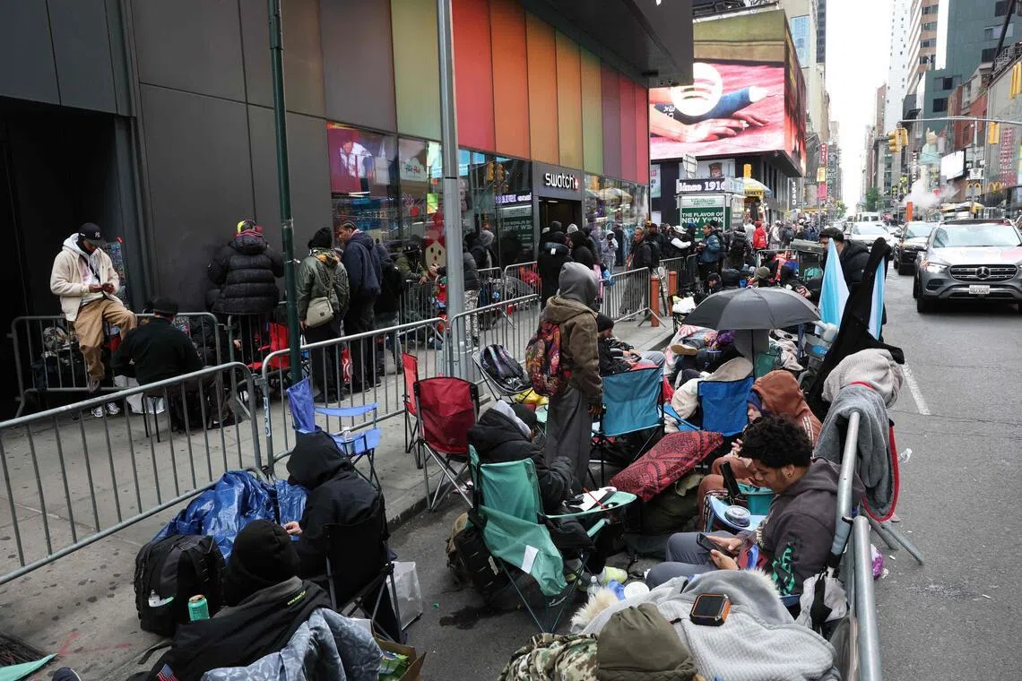 People camp out outside of a Swatch store at Times Square in New York.