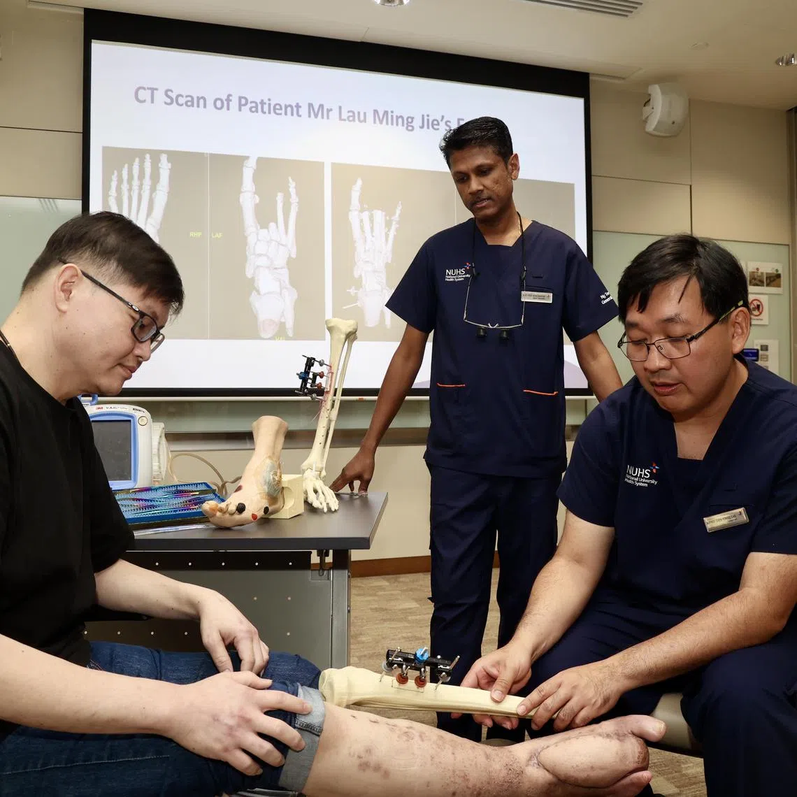 CMG20241212-KwongKC01 /邝启聪/刘安琪/First-known-in-Singapore: reconstruct foot with combi surgery/Adj Asst Prof Vigneswaran N, Head of Division & Senior Consultant, Division of Plastic, Reconstructive & Aesthetic Surgery, NTFGH and Adj A/Prof Chen Yongsheng, Consultant, Division of Orthopaedic Trauma Surgery, NTFGH/ patient Mr Lau Ming Jie