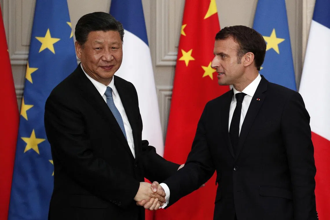 FILE PHOTO: French President Emmanuel Macron and Chinese President Xi Jinping shake hands during a news conference after a meeting at the Elysee Palace in Paris, France March 25, 2019. Yoan Valat/Pool via REUTERS/File Photo