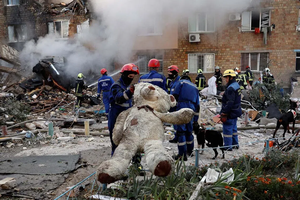 A rescuer holding a soft toy at the site of an apartment building which was hit by Russian missile and drone strikes, amid Russia's attack on Ukraine, in Kyiv, Ukraine, Aug 28, 2025. 