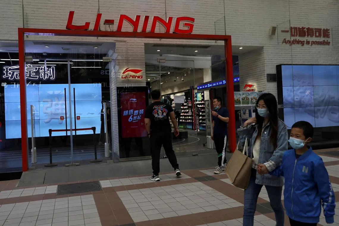 FILE PHOTO: People walk past a store of Chinese sports products brand Li Ning in Beijing, China April 15, 2021. REUTERS/Tingshu Wang/File Photo