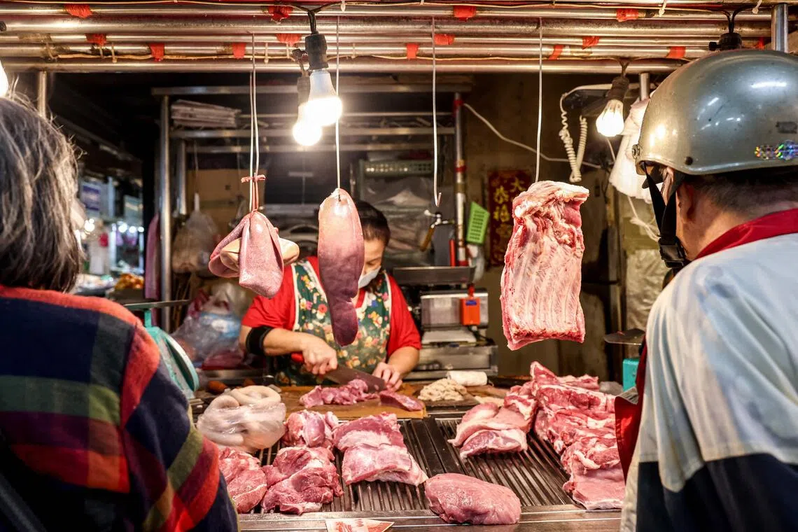 A vendor cuts meat at a pork stall at a local traditional market in Keelung on October 23, 2025. Taiwan has culled dozens of pigs after detecting its first cases of African swine fever, with the agriculture ministry saying on October 23 no other infections have been detected elsewhere on the island.