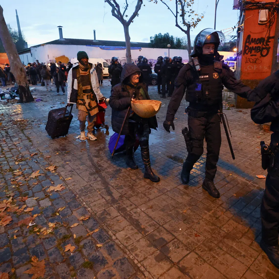 Police officers evict migrants from a former school in Badalona, Spain, December 17, 2025. REUTERS/Albert Gea